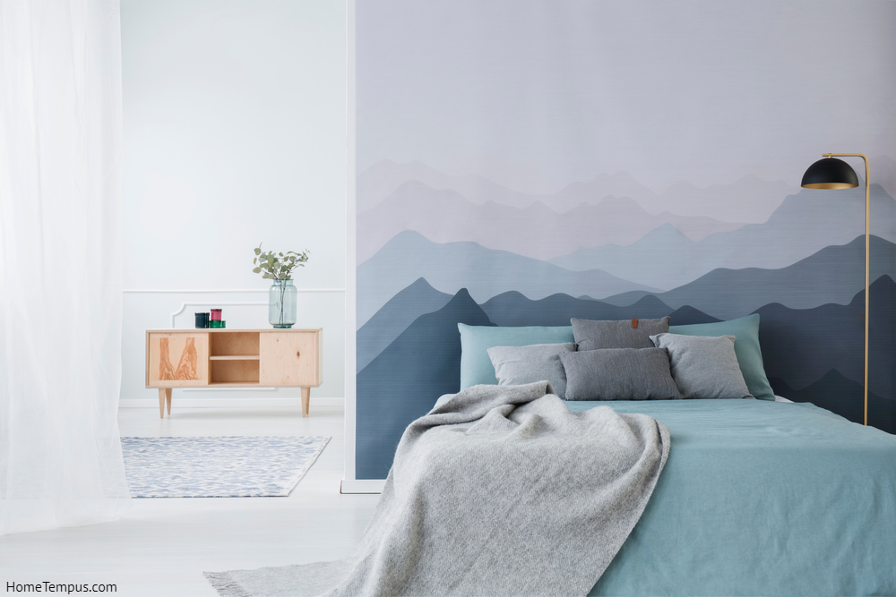 Grey and Blue bedroom ideas - Blue bed with grey blanket against mountain wallpaper in simple bedroom interior with wooden cupboard