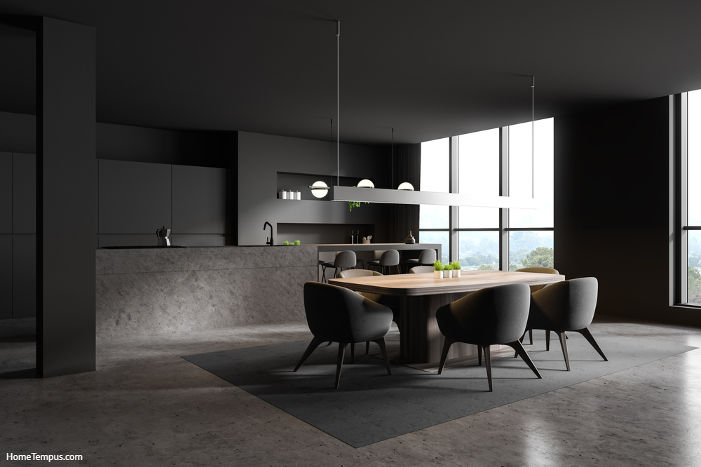 Gray Kitchen Cabinets - Corner of modern kitchen and dining room with dark grey walls, concrete floor, stone island with bar, gray stools and wooden table with chairs