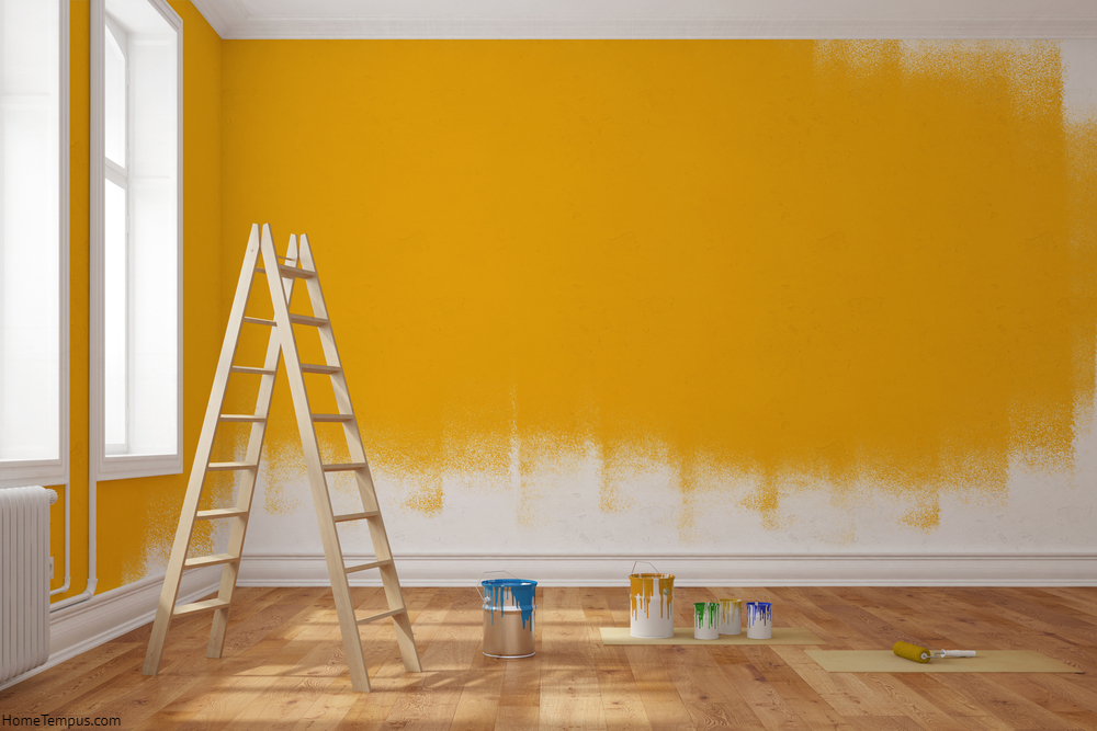 Painting wall yellow in room of apartment after relocation