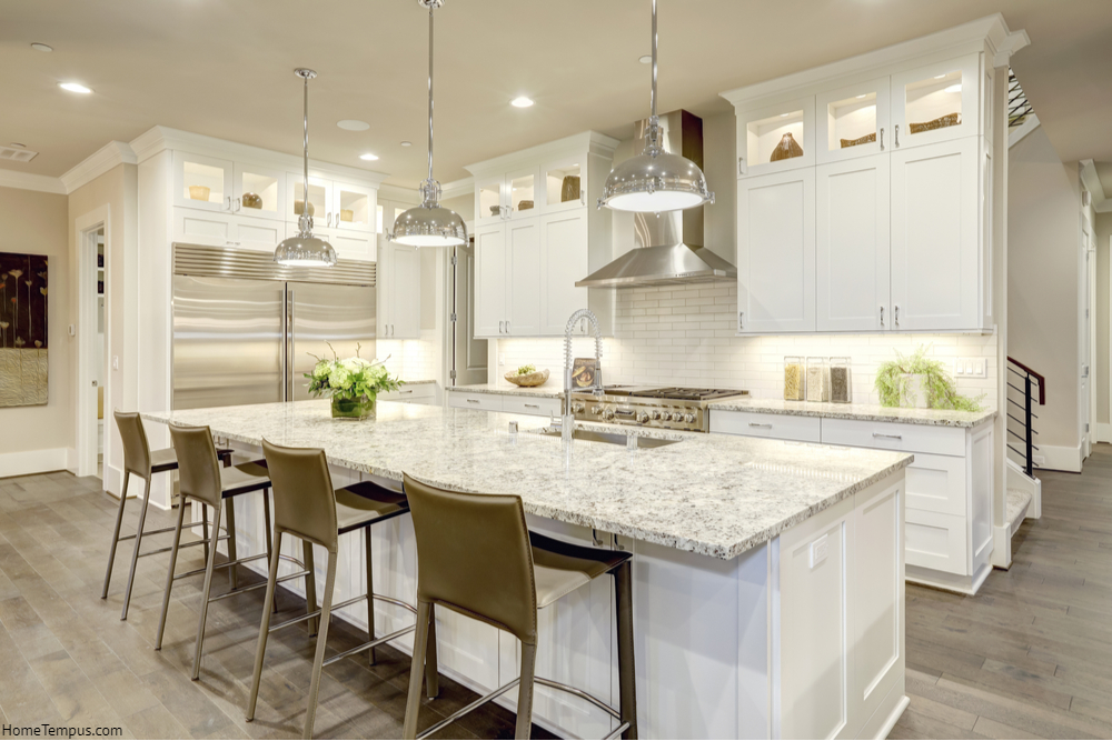 White kitchen design features large bar style kitchen island with granite countertop | kitchen granite countertops