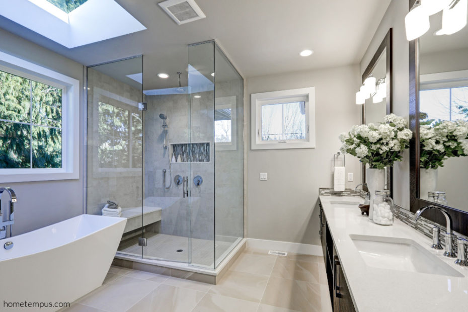 Bathroom ceiling ideas - Spacious bathroom in gray tones with heated floors, freestanding tub, walk-in shower, double sink vanity and skylight